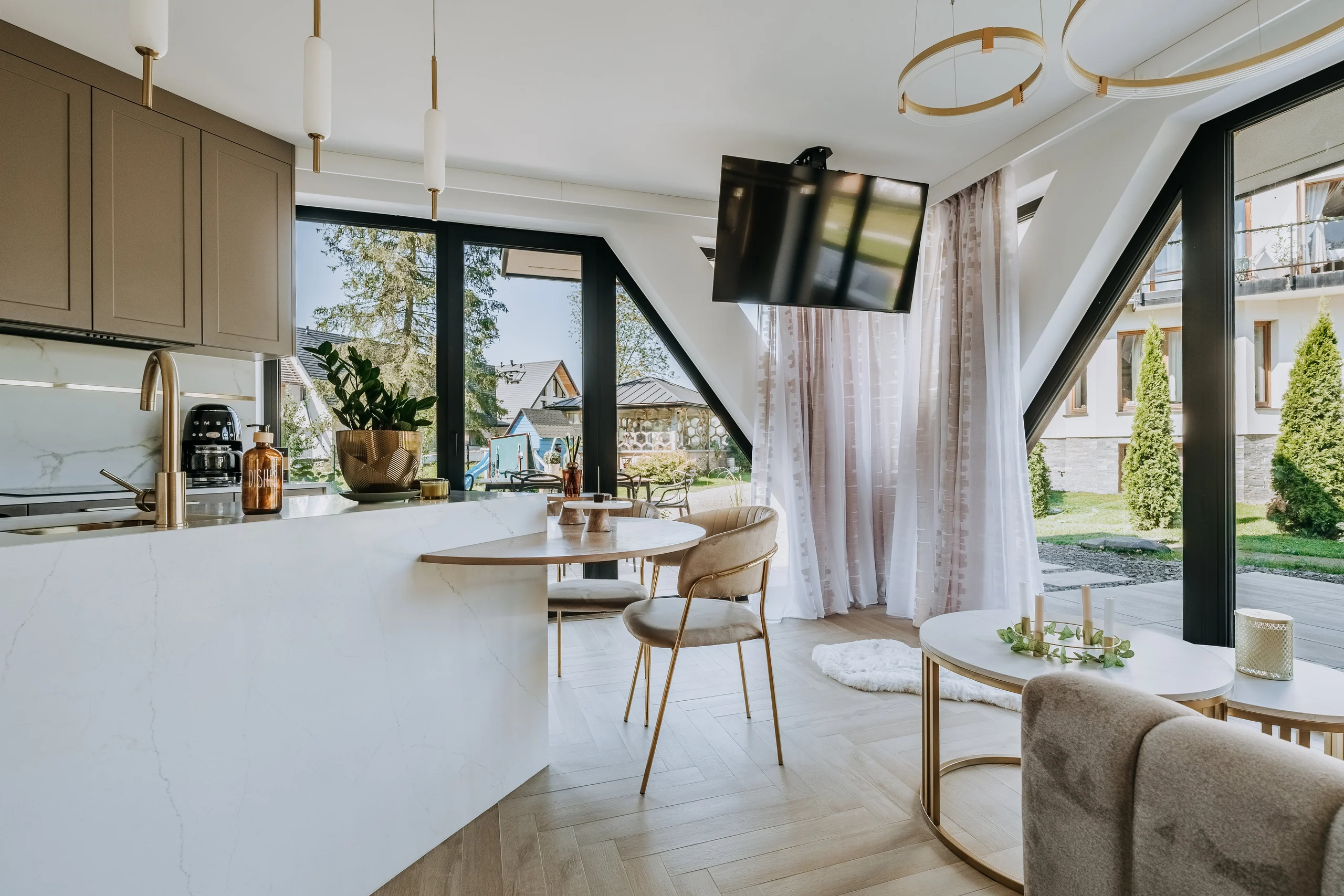 Salon z dużymi oknami i wyjściem na zewnątrz w apartamencie London
