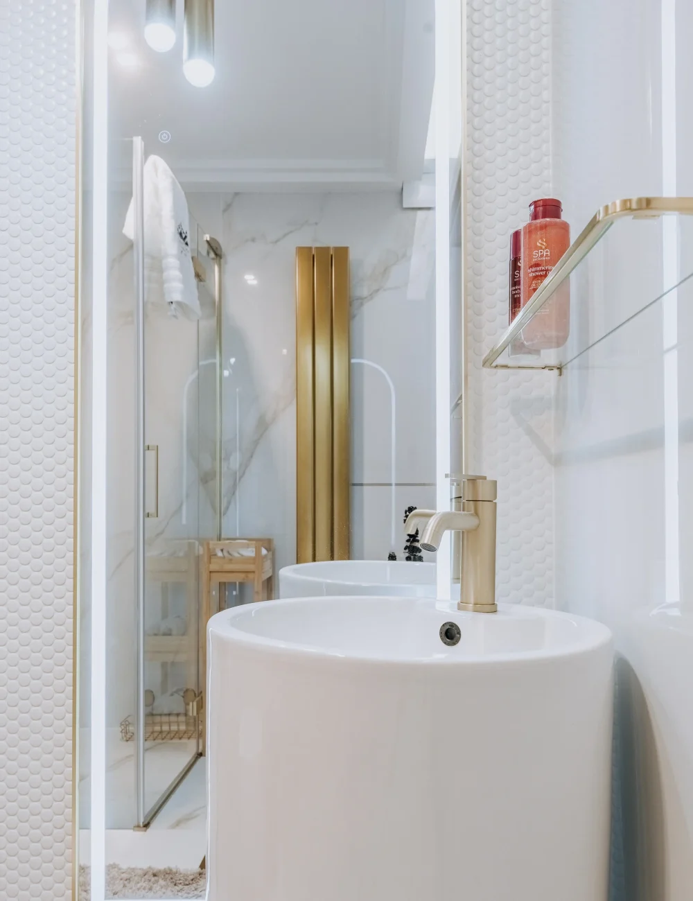 Jasna łazienka z umywalką i dużym lustrem w apartamencie London